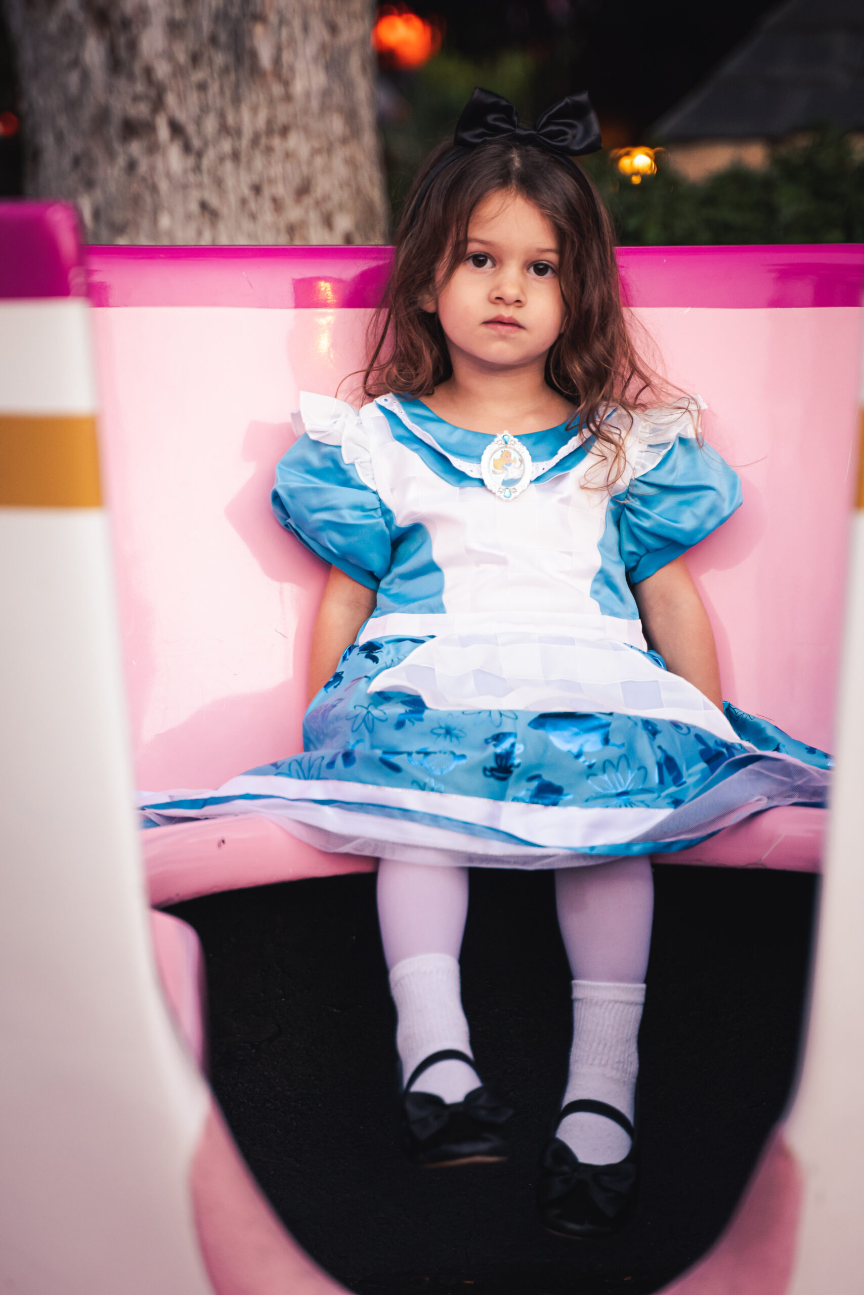 A child dressed as Alice in Wonderland sits in a teacup in Fantasyland at Disneyland in Anaheim, California
